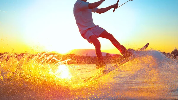 SUN FLARE: Cool surfer dude does 180 ollie while wakeboarding on sunny evening —  Fotos de Stock