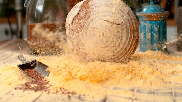 SLOW MOTION: Cadendo pagnotta di pane sparge farina di mais attraverso il tavolo della cucina. — Foto Stock