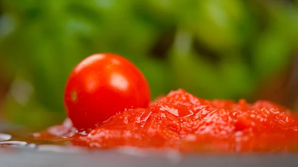 MACRO: Mogna runda tomater faller ner i en pöl med marinarasås på bordet. — Stockfoto