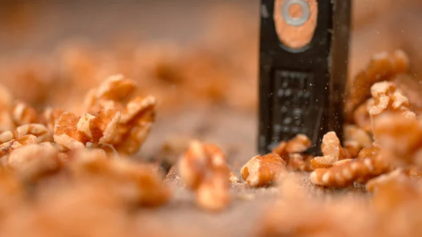 MACRO, DOF : Une personne méconnaissable écrase des noyaux de noix pelés avec un marteau . — Photo