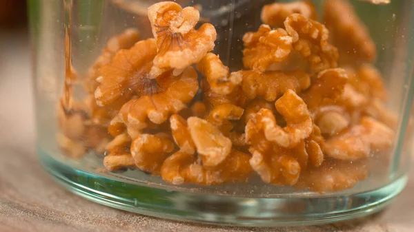 Вкусные ореховые ядра скачут по пластиковому контейнеру блендера . — стоковое фото