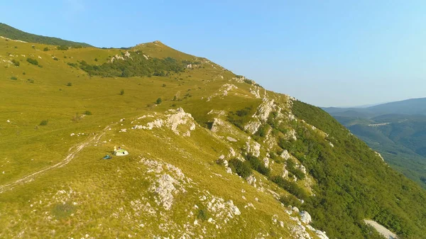 DRONE: Sportieve toeristen die een camping in de spectaculaire bergen opzetten. — Stockfoto