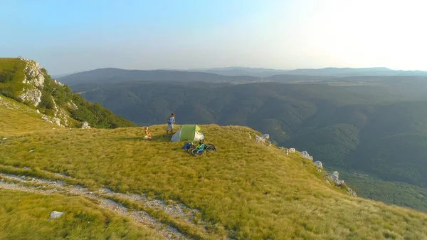 AERIAL: Aktív turista pár készül a kemping a napos hegyek. — Stock Fotó