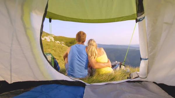 Nah dran: Wandererpaar kuschelt vor seinem Zelt und beobachtet Natur. — Stockfoto
