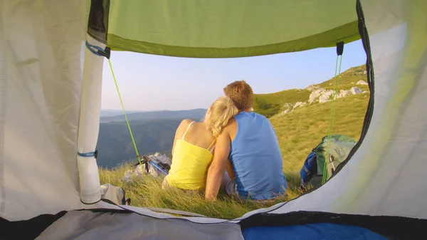 CHIUDI: Coppia turistica spensierata siede vicino alla tenda e osserva il paesaggio. — Foto Stock