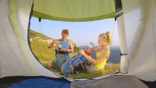 CHIUSURA: Gli escursionisti escursionisti sulle Alpi disfanno le valigie vicino alla tenda. — Foto Stock