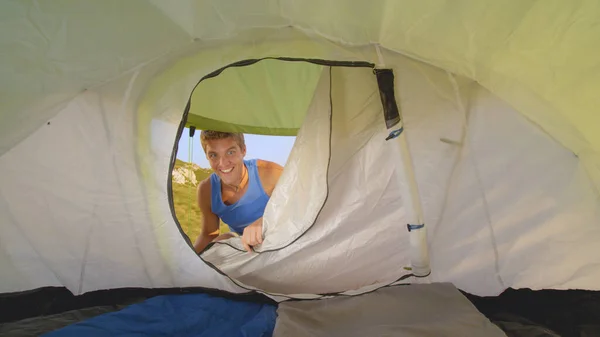 CLOSE UP: Cheerful male tourist opens tent and enters during outdoor adventure — Foto de Stock