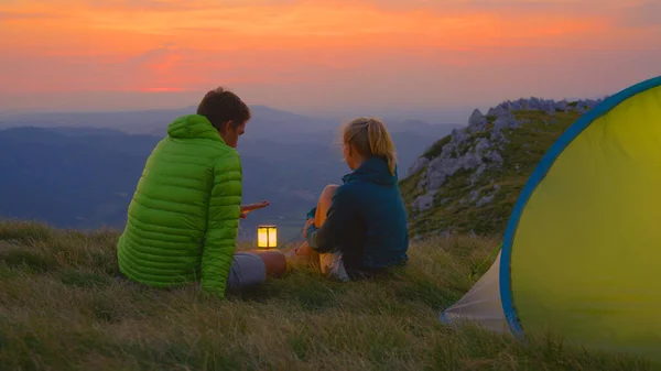 FECHAR UP: Casal despreocupado acampando nos Alpes observando a paisagem da noite — Fotografia de Stock