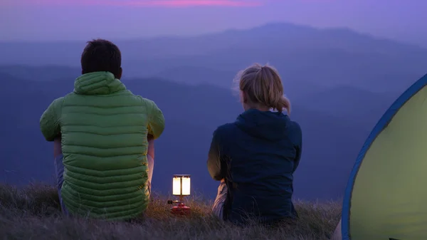 CLOSE UP: Unrecognizable couple sitting by the lantern and observing the nature. — Foto de Stock