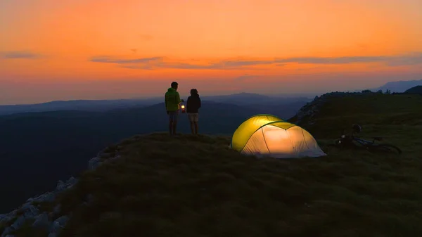 DRONE: coppia che osserva l'alba durante una divertente gita in mountain bike nelle Alpi . — Foto Stock