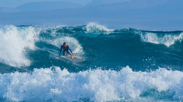 Young pro surfer dude surfing fun ocean waves in the sunny Canary Islands. — Photo