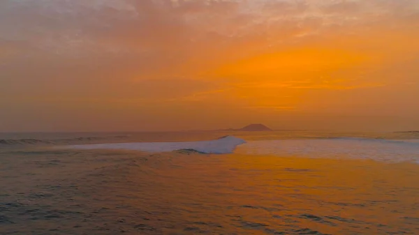 DRONE : Survoler une petite vague océanique roulant vers la plage au lever du soleil. — Photo