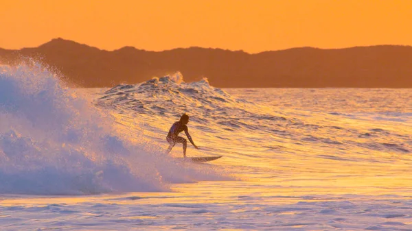 Surfare snubben hukar på sin surfbräda samtidigt surfa en vacker bryta våg — Stockfoto