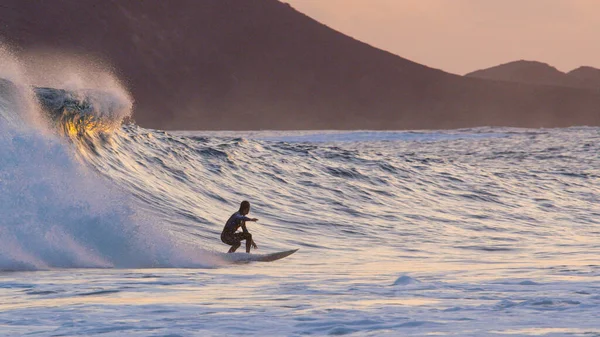 Atletisk surfare snubbe snida stora bryta våg vid färgglada sommar solnedgång. — Stockfoto