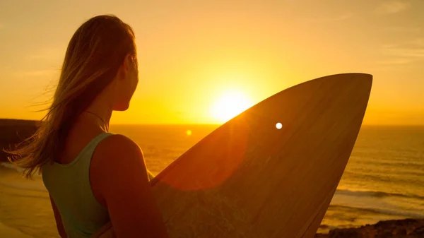LENS FLARE: Sportig kvinna som har kul att titta på den idylliska solnedgången och lugna havet. — Stockfoto