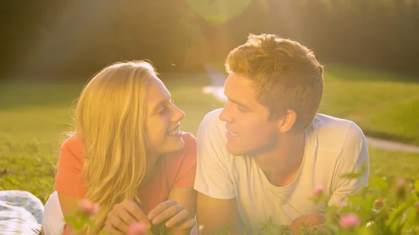 Nah dran: Junger Mann und Frau im Gespräch auf der ruhigen, sonnigen Wiese. — Stockfoto