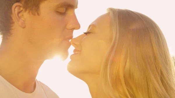 LENS FLARE: Caring man kisses his gorgeous girlfriend on a sunny summer day. — Stock Photo, Image