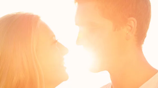 CLOSE UP: Schöner Mann lehnt sich an und küsst lächelnde Freundin in seiner Umarmung. — Stockfoto