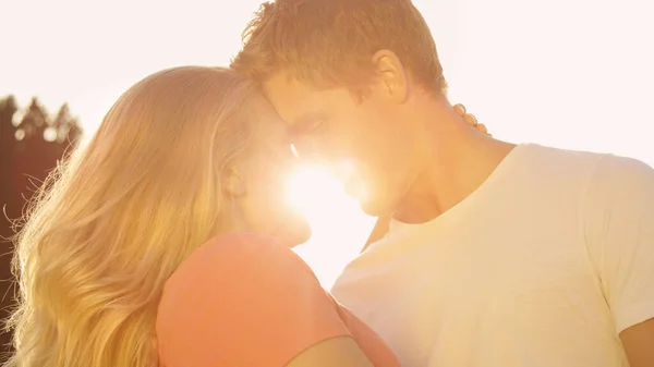 LENS FLARE: Young lovers touching foreheads before kissing over the sunset. — стоковое фото