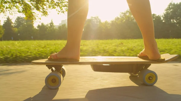 Sluiten: Onherkenbare actieve vrouw schaatsen door het rustige zonovergoten park. — Stockfoto