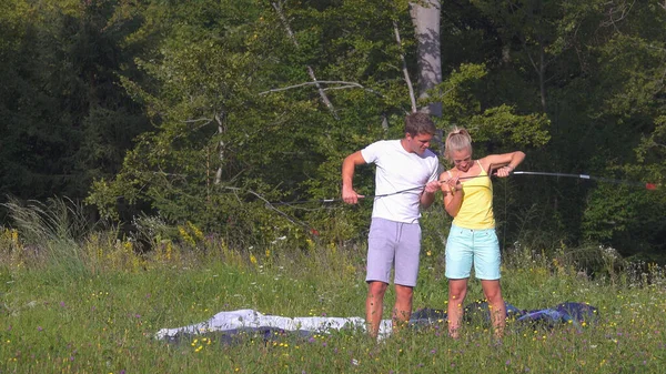 Junges Paar baut während eines lustigen Zeltabenteuers gemeinsam ein Zelt auf — Stockfoto