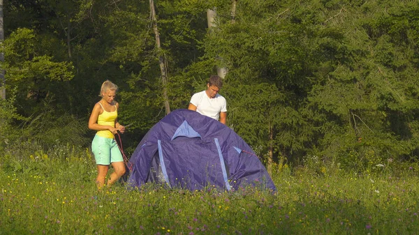 Tourist couple successfully sets up a tent and campsite during a camping journey — стоковое фото