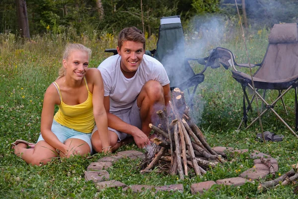 PORTRAIT: Glückliches Reisepaar sitzt an einem Sommerabend am Lagerfeuer. — Stockfoto