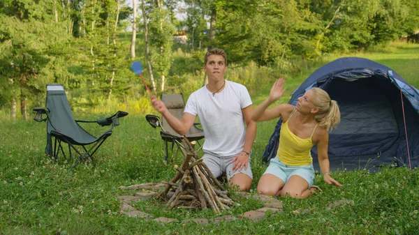 Mann fängt an, eine Fliegenklatsche zu schleudern, als das Paar von irritierenden Wanzen angegriffen wird — Stockfoto