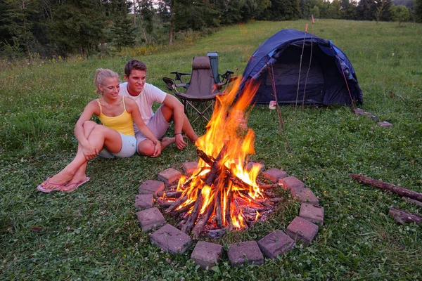 CLOSE UP: Unbekümmerte Frau kuschelt sich am Feuer an ihren Freund. — Stockfoto