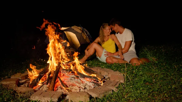 CLOSE UP: Joyful couple touching foreheads while snuggling by the firepit. — Foto Stock