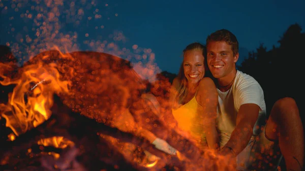 FECHAR UP: Mulher feliz rindo enquanto ela abraça o namorado junto ao fogo. — Fotografia de Stock