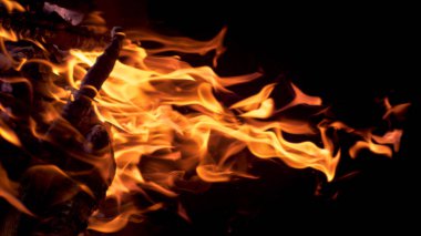 VERTICAL MACRO: Bright bonfire burning in the darkness of a cold summer night.