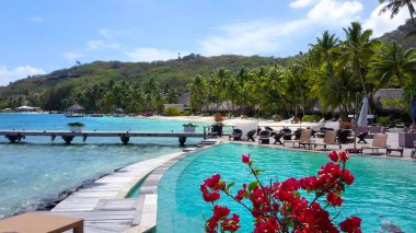Wooden walkway leading towards the empty sandy beach and oceanfront bungalows.