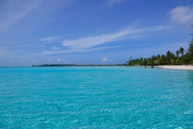 AERIAL: Breathtaking view of calm turquoise ocean surrounding tropical island.