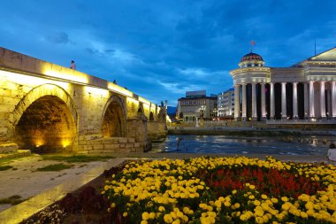 Beautiful view of an ancient building across the river and colorful garden.