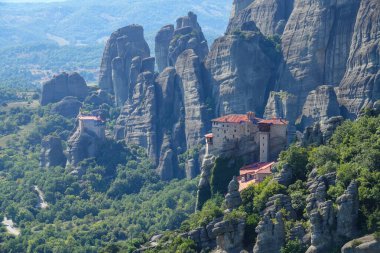 Taş bir oluşumun üzerine inşa edilmiş eski Yunan manastırının etrafında uçmak