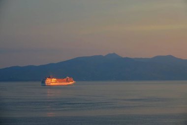 Beautiful cruise ship shines in the golden morning sunbeams after leaving port.
