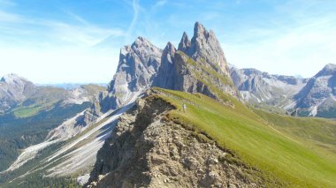 Aktif kadın ve siyah yavrusu çimenli dağın tepesinde yürüyor..