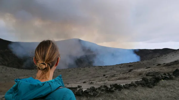 FERMER : Voyageuse méconnaissable assise sur le bord d'un volcan actif . — Photo