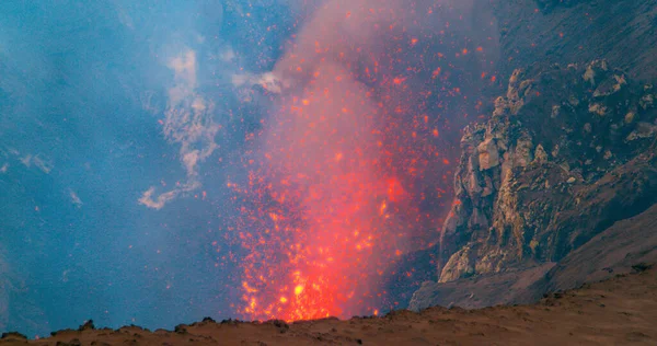 CHIUDI: Luminosi pezzi arancioni di lava fusa che volano nell'aria durante un'eruzione — Foto Stock