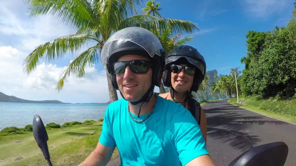 SELFIE: Cheerful man and woman riding on a scooter along the scenic coastal road —  Fotos de Stock