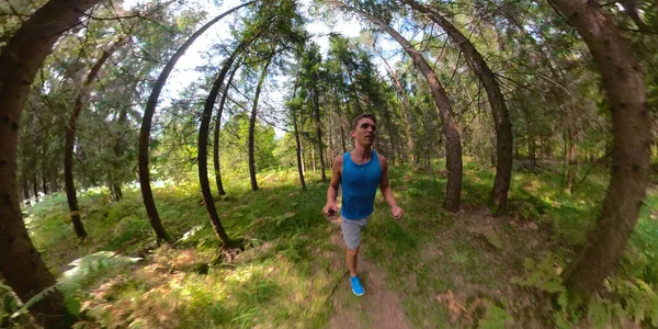 Fit τύπος τρέχει μέσα από το γραφικό δάσος σε μια τέλεια μέρα του καλοκαιριού. — Φωτογραφία Αρχείου