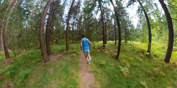 VR 360: Onherkenbare jonge mannelijke jogger loopt over een schilderachtig bospad. — Stockfoto