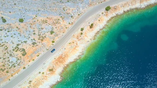 AERIAL: People cruising along the stunning shoreline of Lefkada in a grey car. — Stock Photo, Image