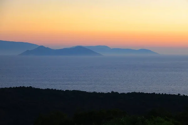 AERIAL: Mist rises from the ocean as the golden sun rises in the early morning. — Stock Photo, Image