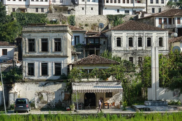 Pria lokal yang lebih tua berjalan melewati rumah bersejarah yang indah di Berat, Albania. — Stok Foto