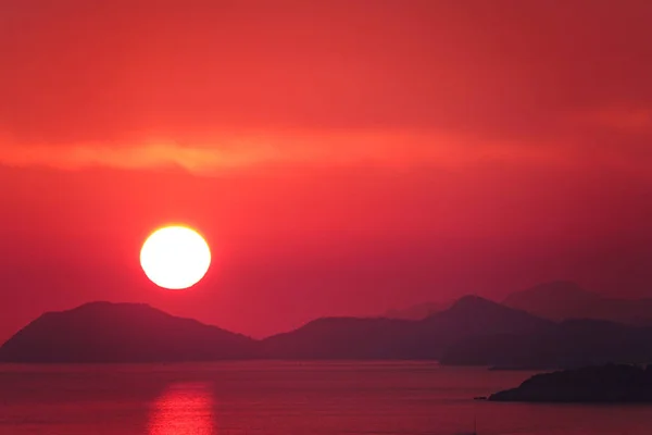 AEREO Volare verso il sole arancione che scende dietro il paesaggio tranquillo dell'isola — Foto Stock