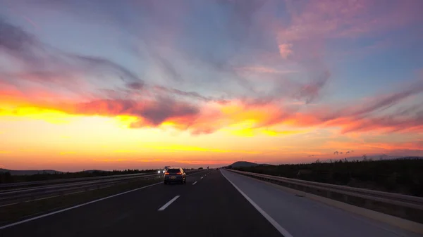 АЭРИАЛ: Красочный закат освещает шоссе, проходящее через спокойную сельскую местность . — стоковое фото