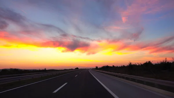 Живописный снимок заката, сияющего на шоссе, пересекающем страну . — стоковое фото