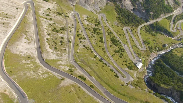 AERIAL: Flying above a scenic switchback road leading up to a mountain pass. — Foto de Stock